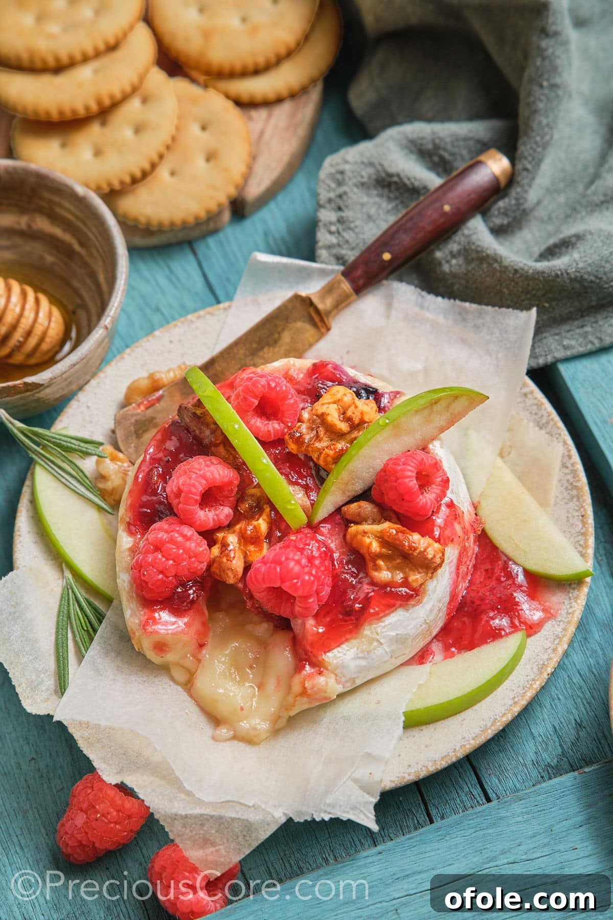 Round baked brie topped with fig preserves, fresh raspberries, and candied walnuts.