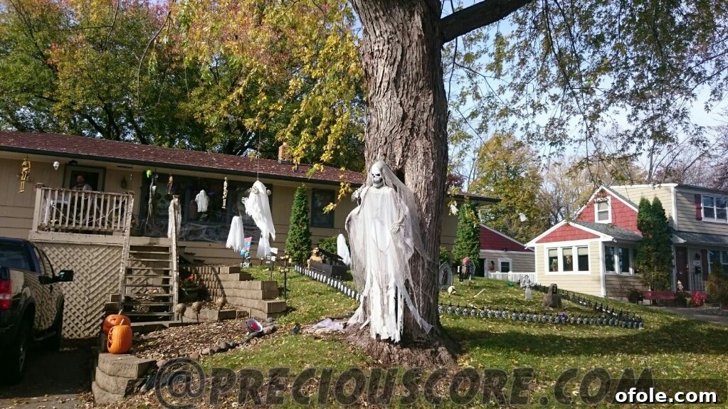 A unique and spooky Halloween yard decoration, possibly an inflatable monster or a complex tableau of creepy characters illuminated at night.