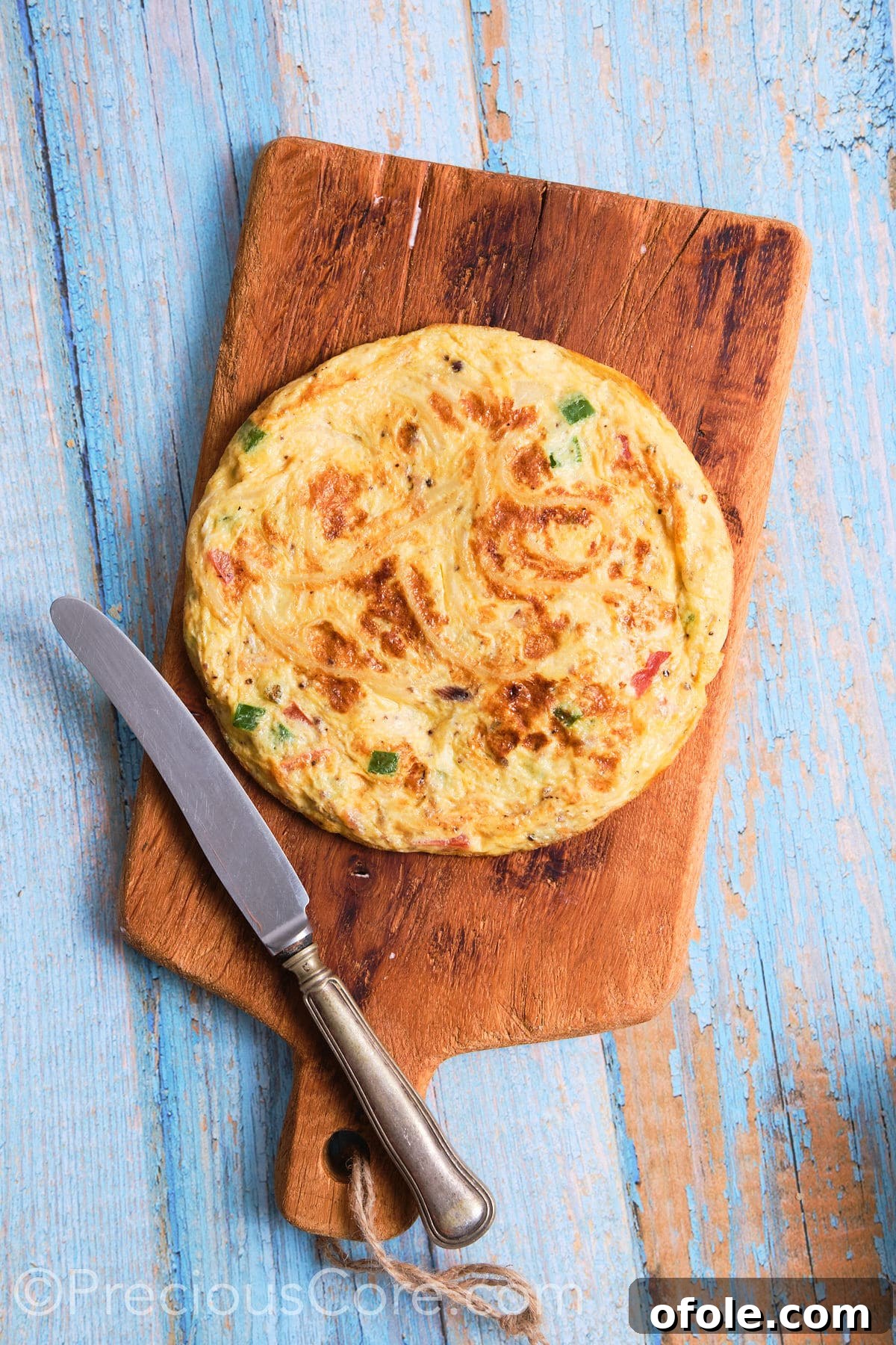Cameroon's Signature Spaghetti Omelette Sandwich 10 A freshly cooked spaghetti omelette placed on a cutting board, ready to be sliced.