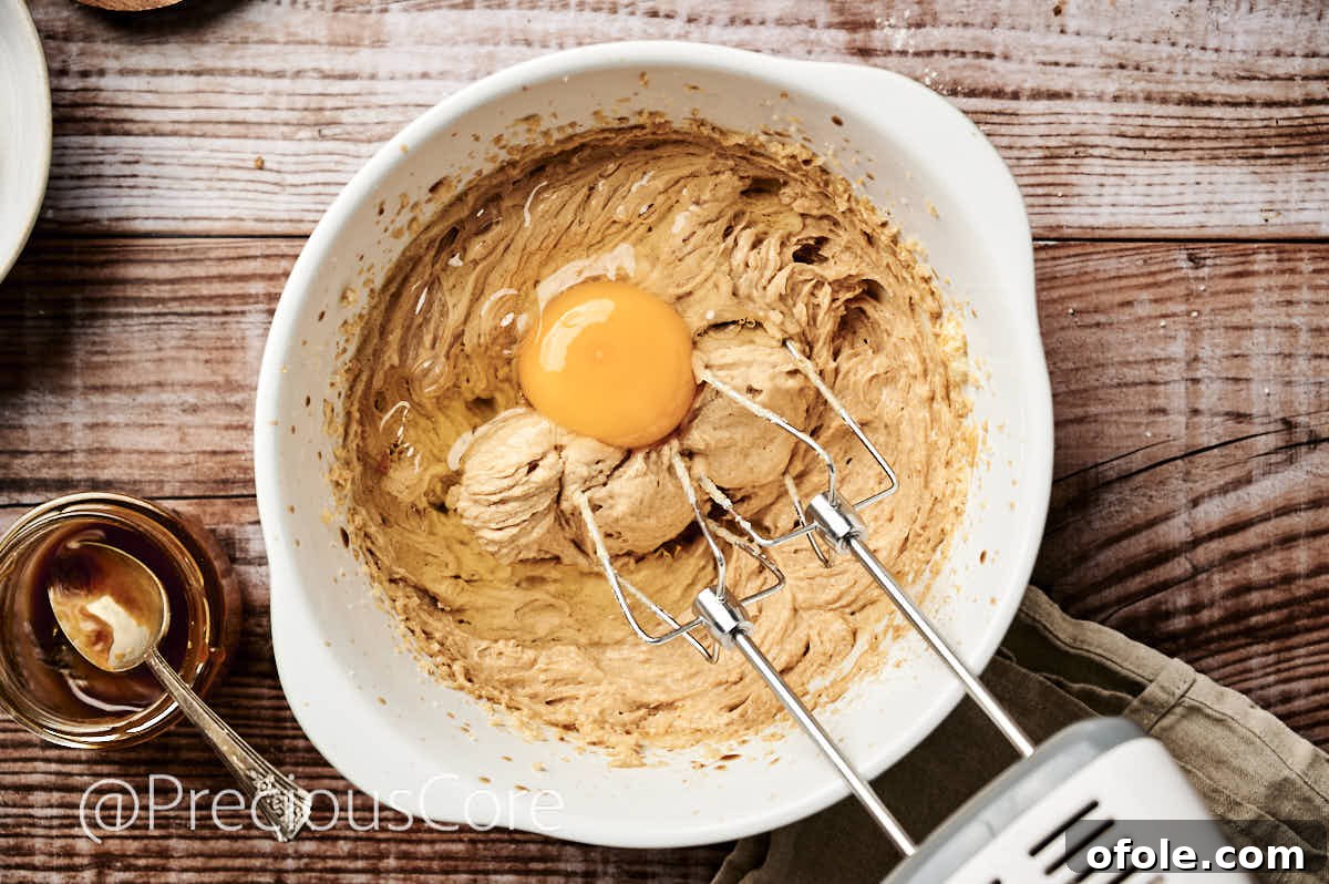 Salted Caramel Dream Cake 8 Adding room temperature eggs one by one to the creamed butter and sugar mixture.
