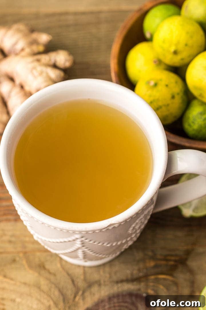 Zesty Ginger Brew 2 A mug of fresh ginger drink with some ginger slices and key limes on the side, ready to be enjoyed as an immunity booster.