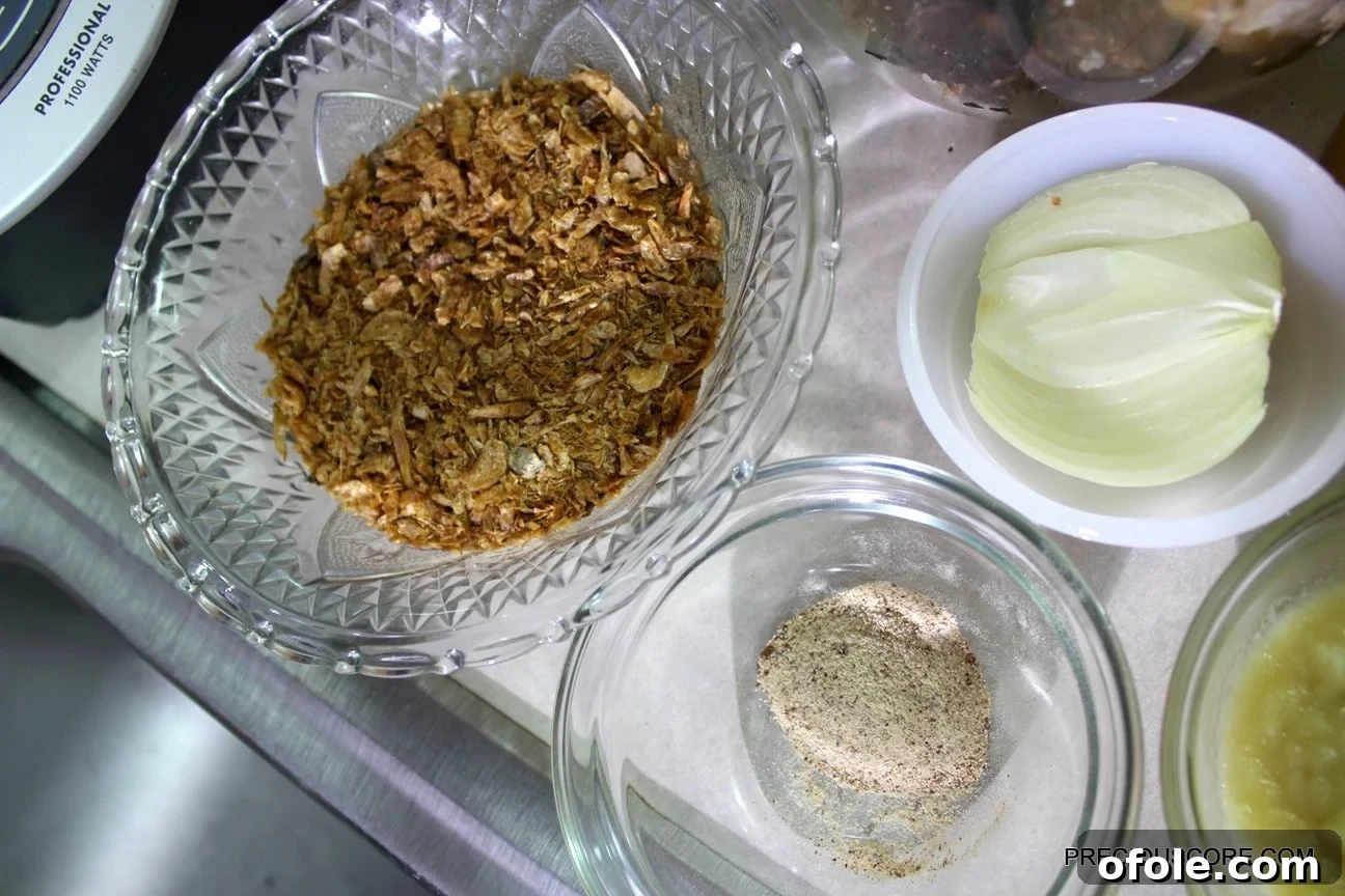 Various Ekwang ingredients, including cocoyams, palm oil, crayfish, and fresh vegetables, neatly arranged on a kitchen countertop.