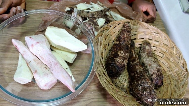Two bowls on a countertop: one filled with unpeeled cocoyams, the other with neatly peeled ones, showcasing the preparation stage.