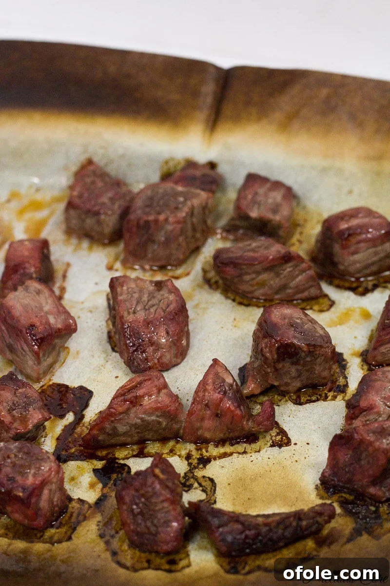 African Smokehouse Secrets for Your Home 3 Cooked meat on a lined baking sheet.
