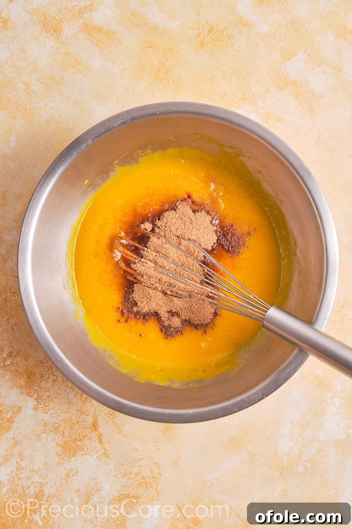 Creamy Pumpkin Pie Without Evaporated Milk 11 Various spices and brown sugar being added to the egg and pumpkin puree mixture in a bowl, showing the beginning of the filling preparation.