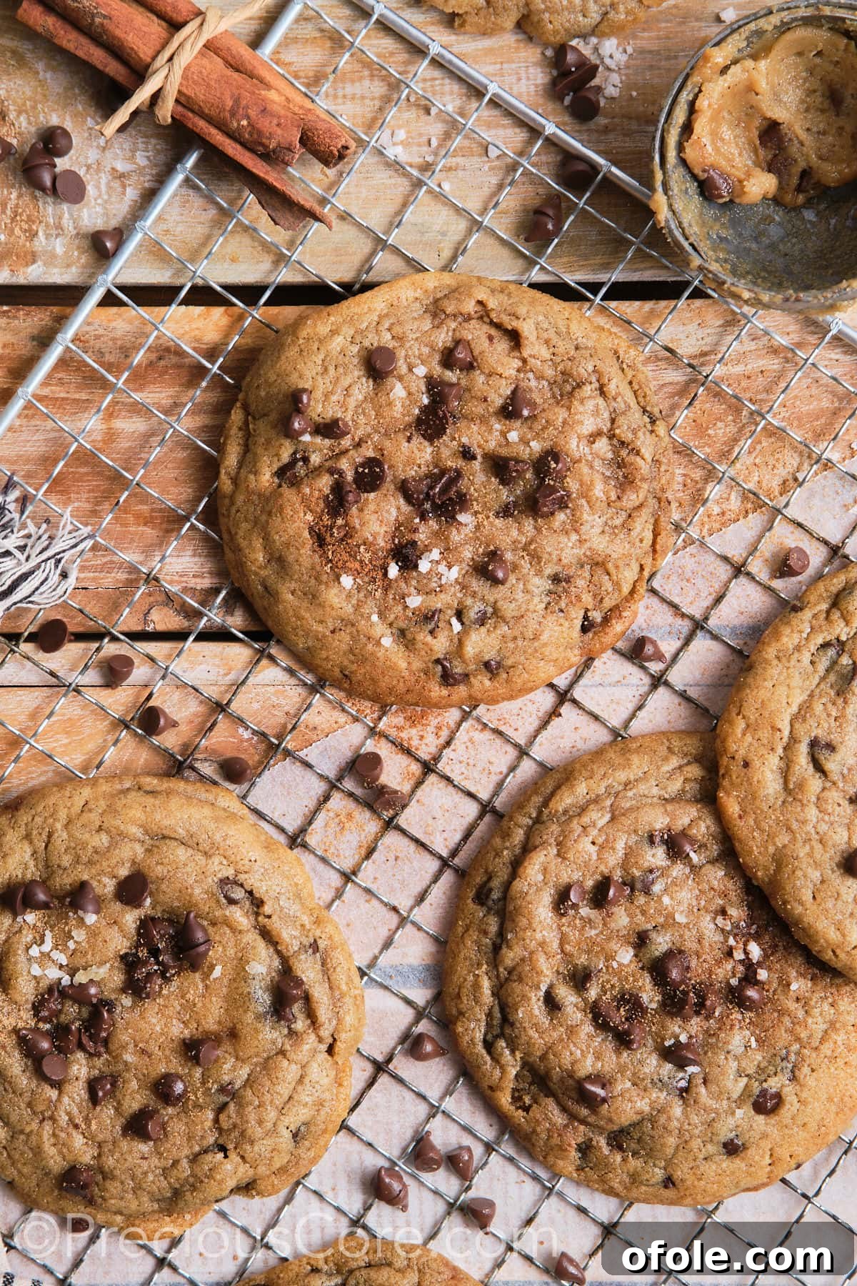 Cinnamon chocolate chip cookies on a wire rack, sprinkled with sea salt