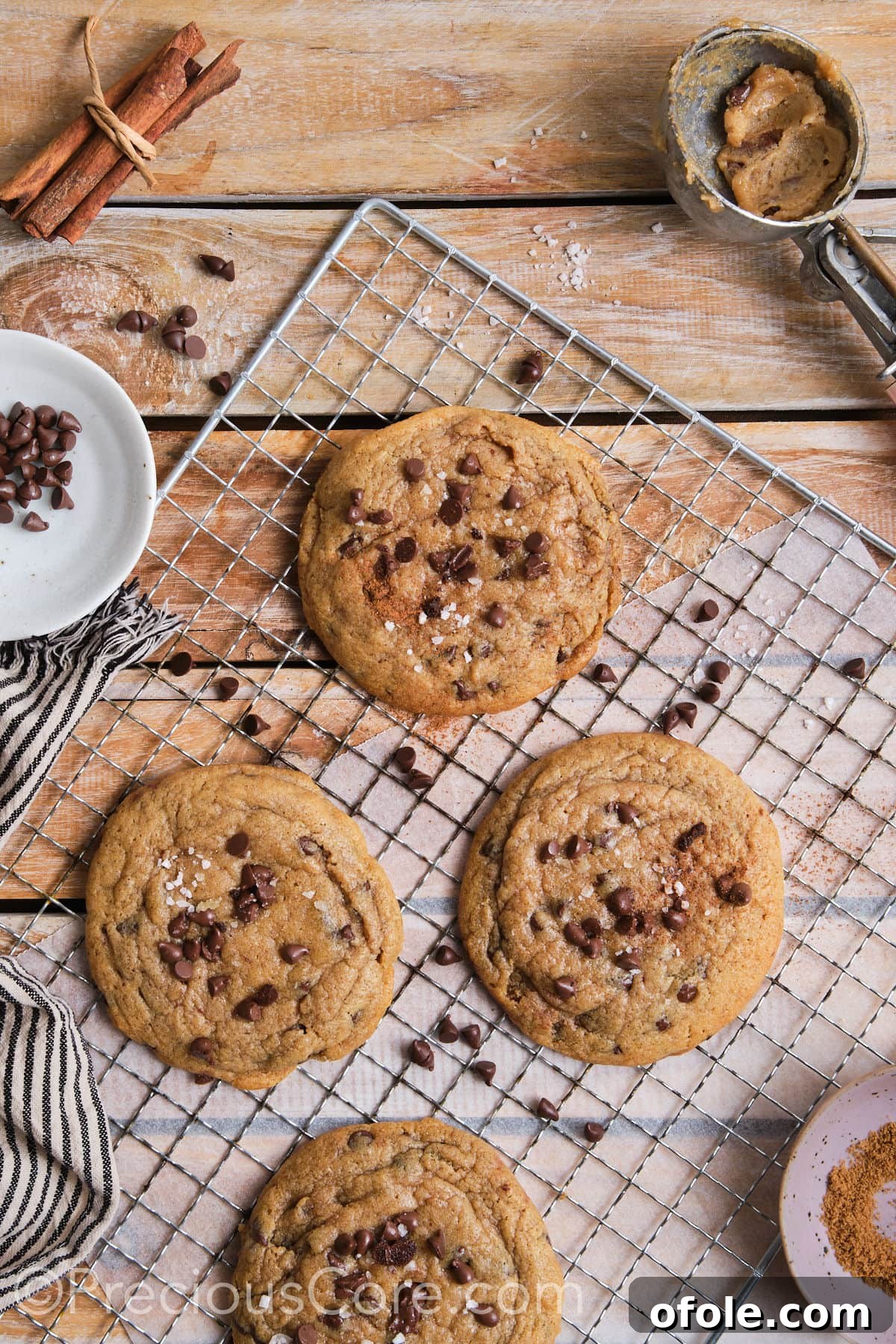wire rack with cinnamon and chocolate chip cookies topped with flaky sea salt. 