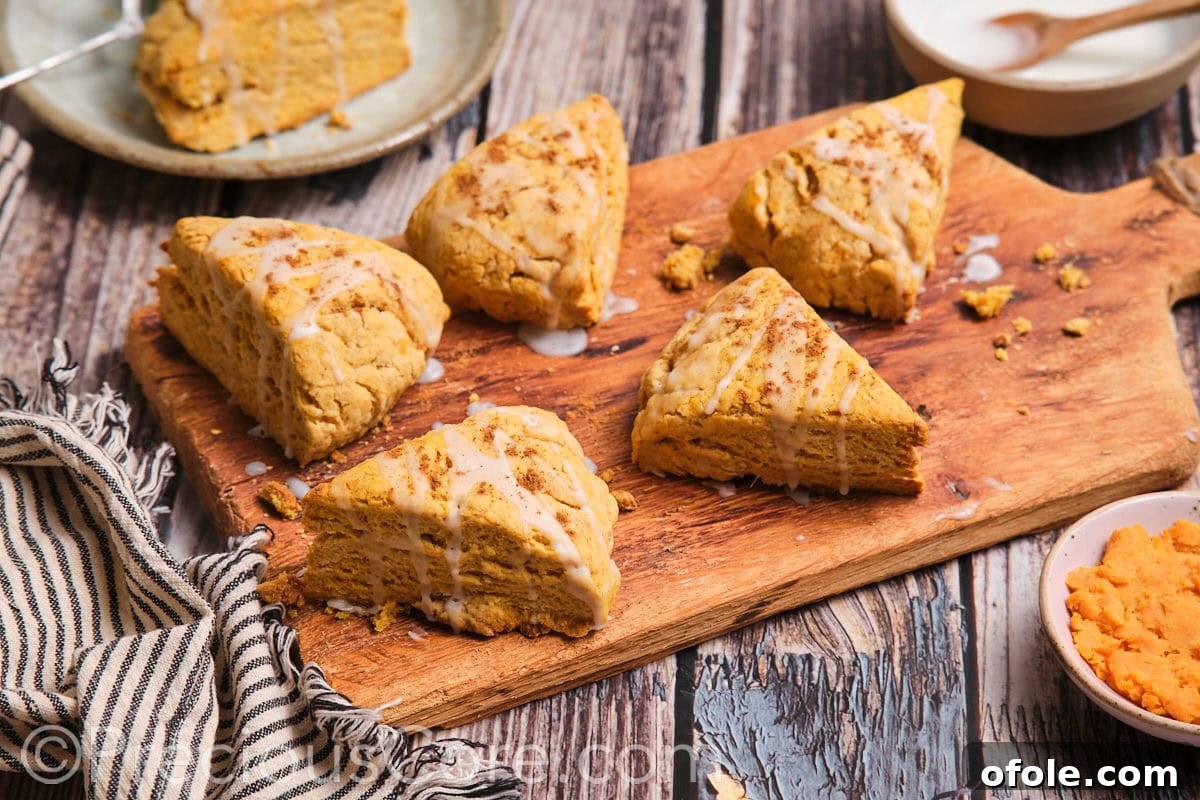Golden Sweet Potato Scones 3 A collection of delicious sweet potato scones arranged beautifully on a rustic wooden chopping board, ready to be served.