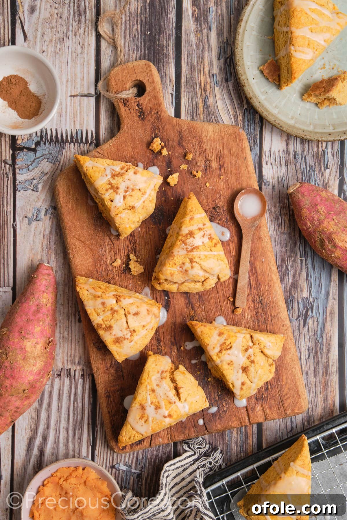 Golden Sweet Potato Scones 5 Freshly baked sweet potato scones, golden and inviting, artfully arranged on a wooden chopping board, awaiting their sweet glaze.
