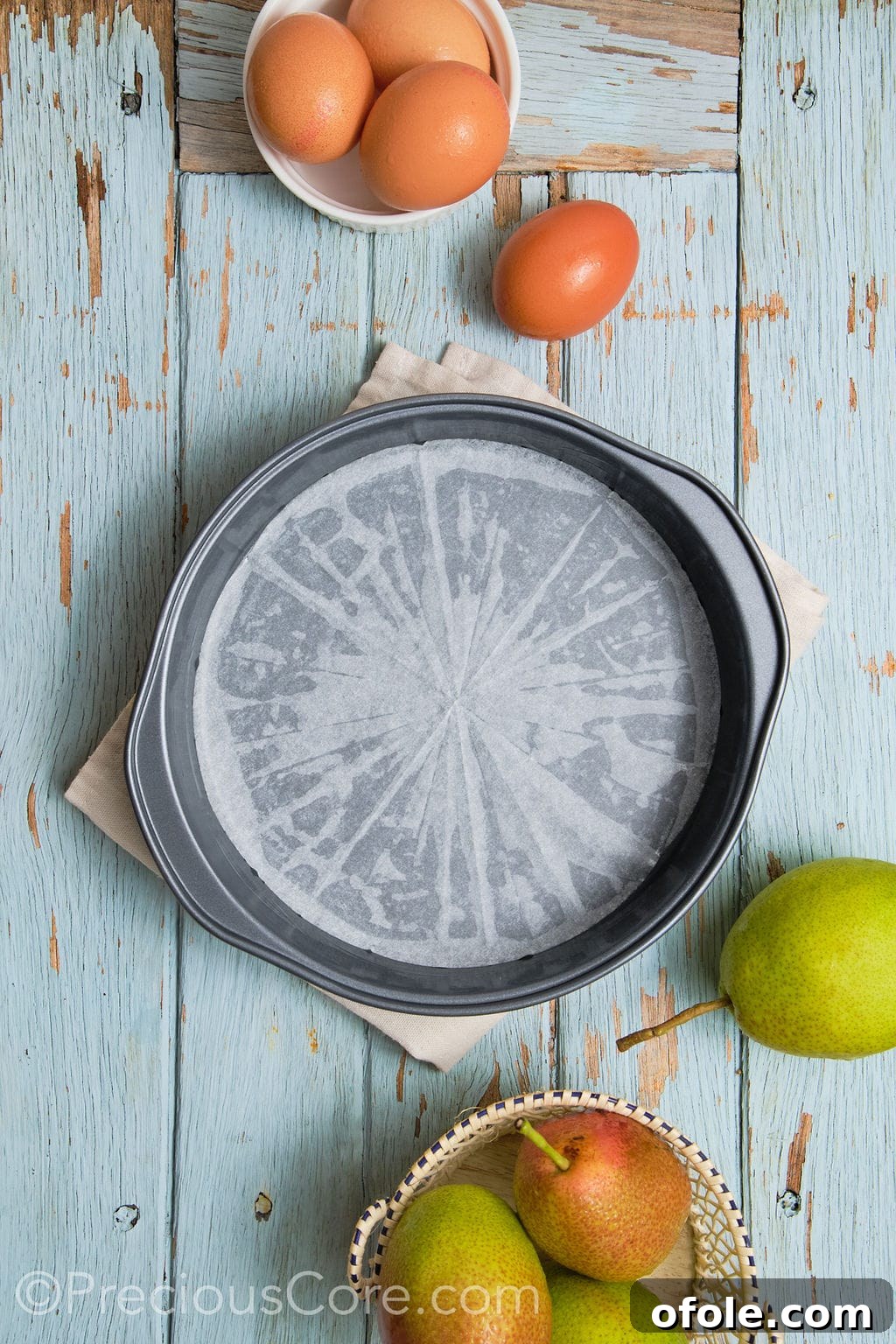 A round cake pan or springform pan properly greased with butter and lined with parchment paper, ready for the cake batter.