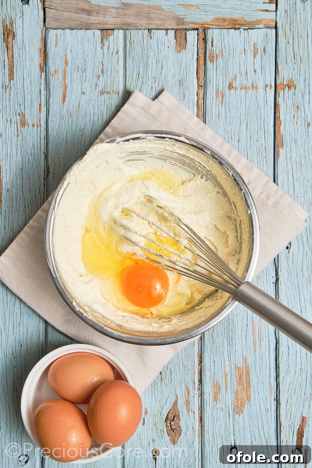 Eggs being whisked thoroughly into the creamed butter and sugar mixture, creating a smooth and cohesive batter.