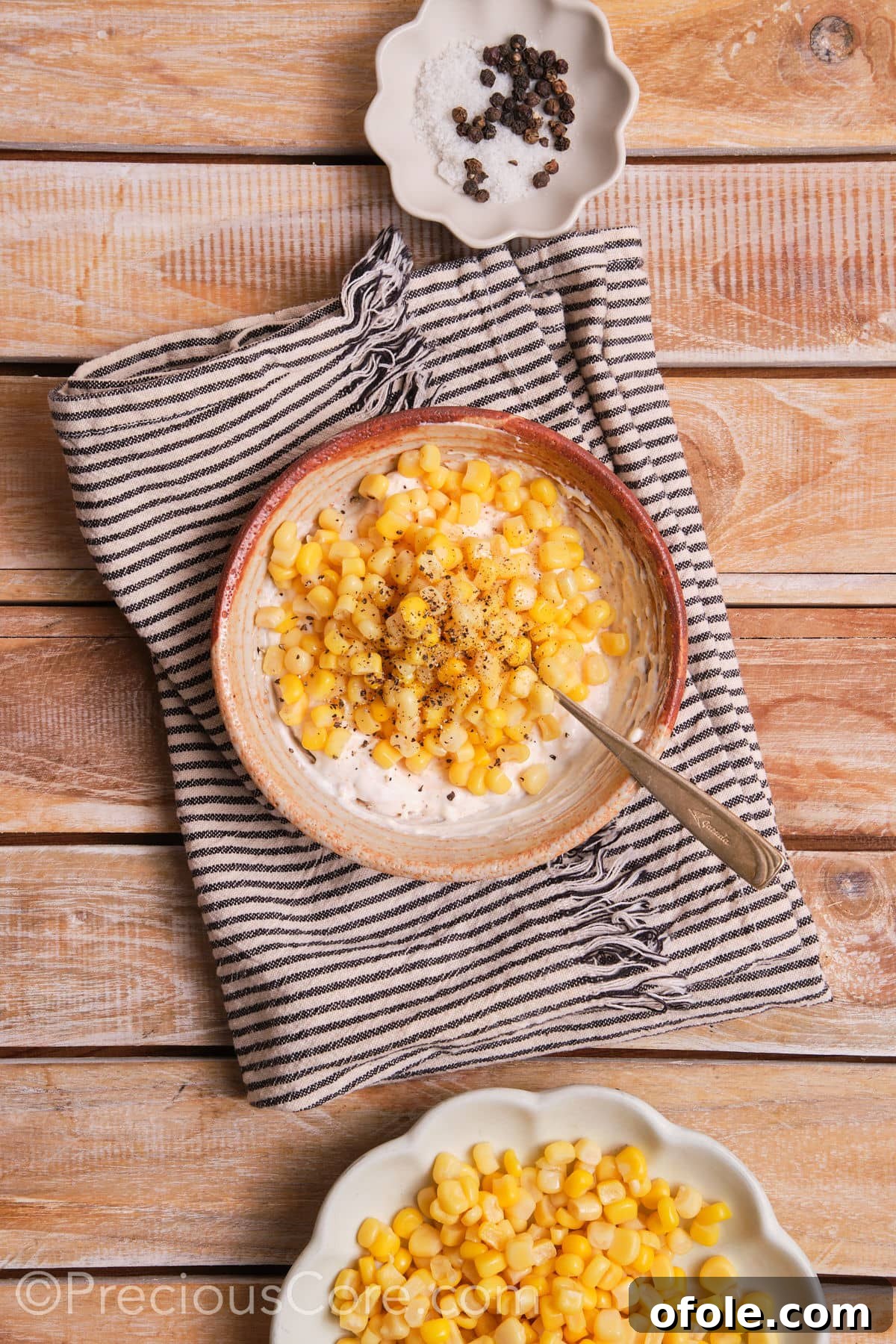 Fiesta Street Corn Bake 5 Thawed corn kernels being mixed into a rich, creamy sauce in a bowl, ready for baking.