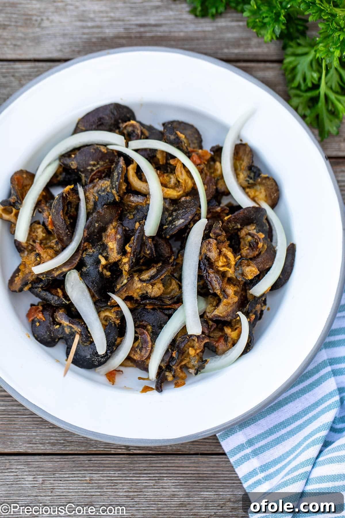 Savoring Cameroon's Snail Delicacy 2 A vibrant plate of Cameroonian snails, garnished with fresh sliced onions, ready to be enjoyed.