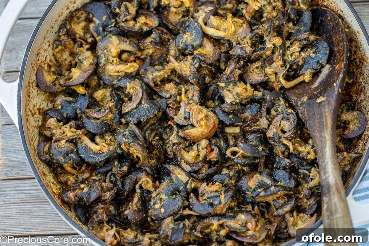 Savoring Cameroon's Snail Delicacy 3 Cameroonian snails simmering in a rich, flavorful sauce inside a cooking pot.