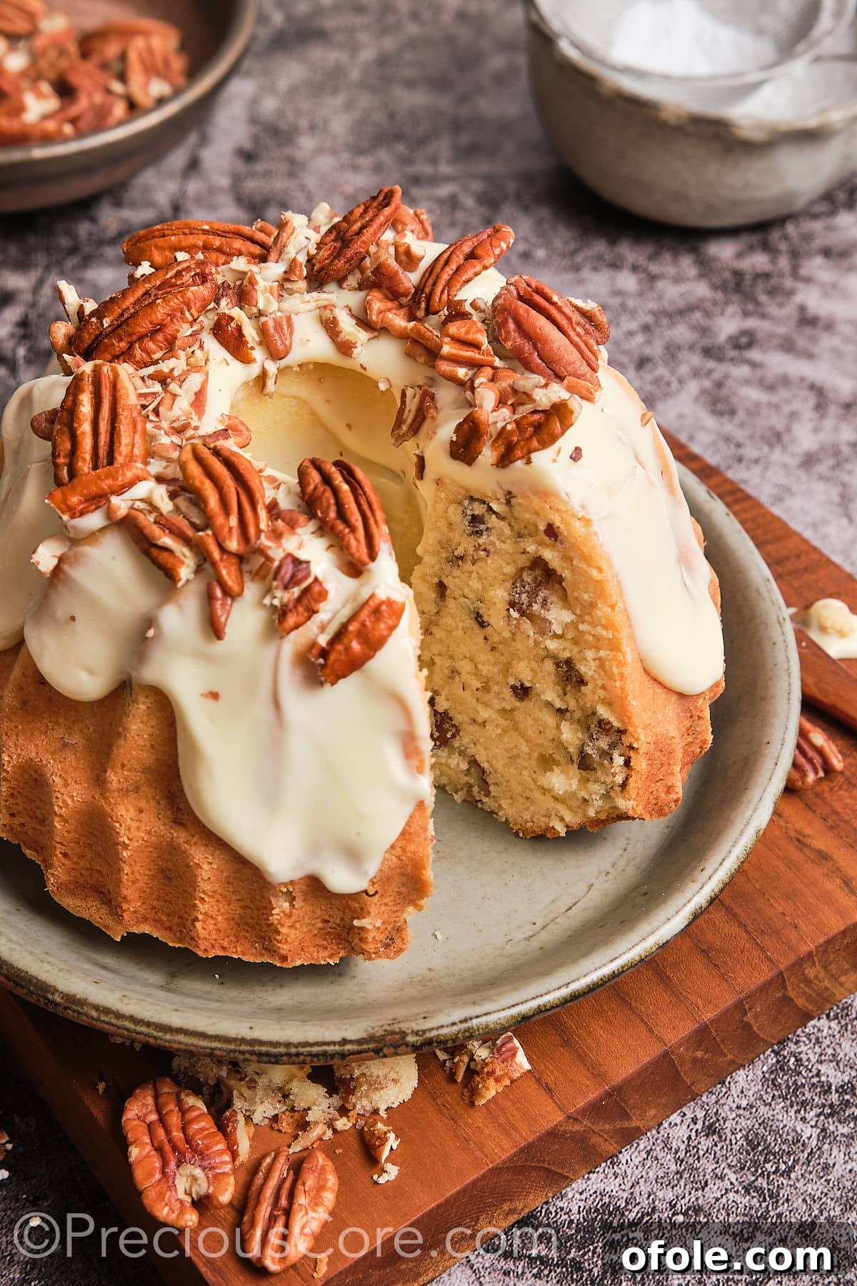 Southern Butter Pecan Pound Cake 2 Butter pecan pound cake with a slice taken out, showcasing the moist interior and generous frosting.