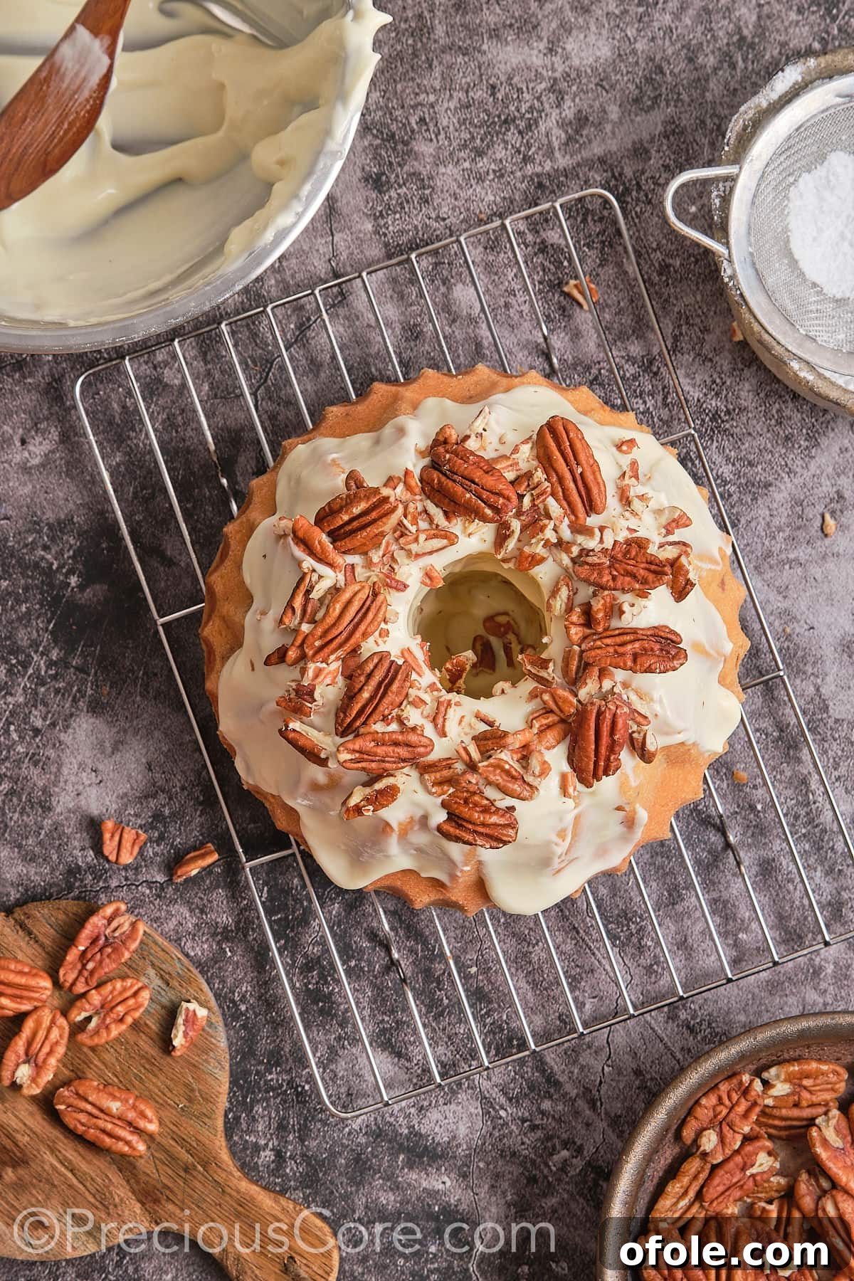 Southern Butter Pecan Pound Cake 17 Garnishing the frosted butter pecan pound cake with additional pecan nuts.