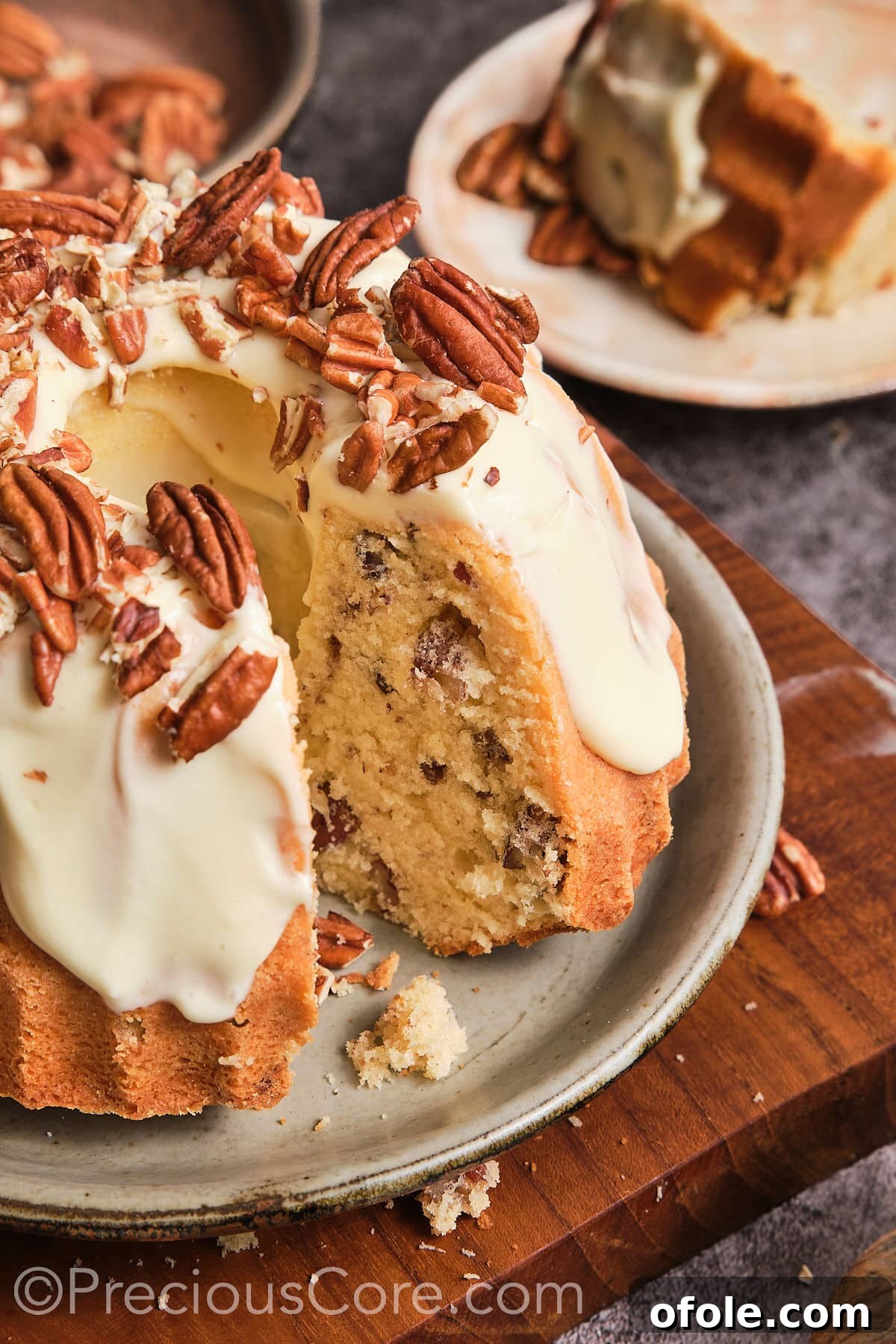 A close-up, artistic shot of the Butter Pecan Pound Cake, highlighting its intricate Bundt shape, rich frosting, and pecan pieces.