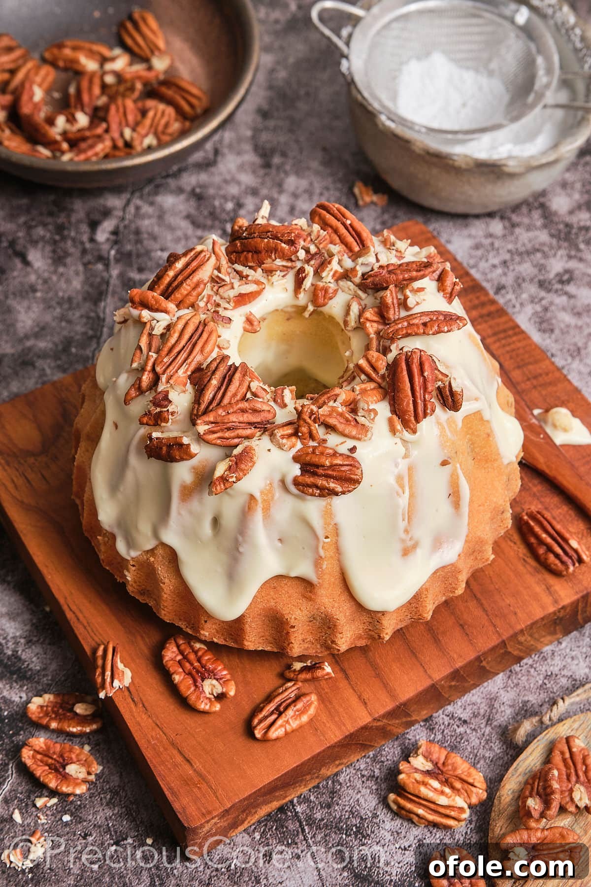 Southern Butter Pecan Pound Cake 19 A delicious whole Butter Pecan Pound Cake displayed beautifully on a wooden plank, ready to be served.