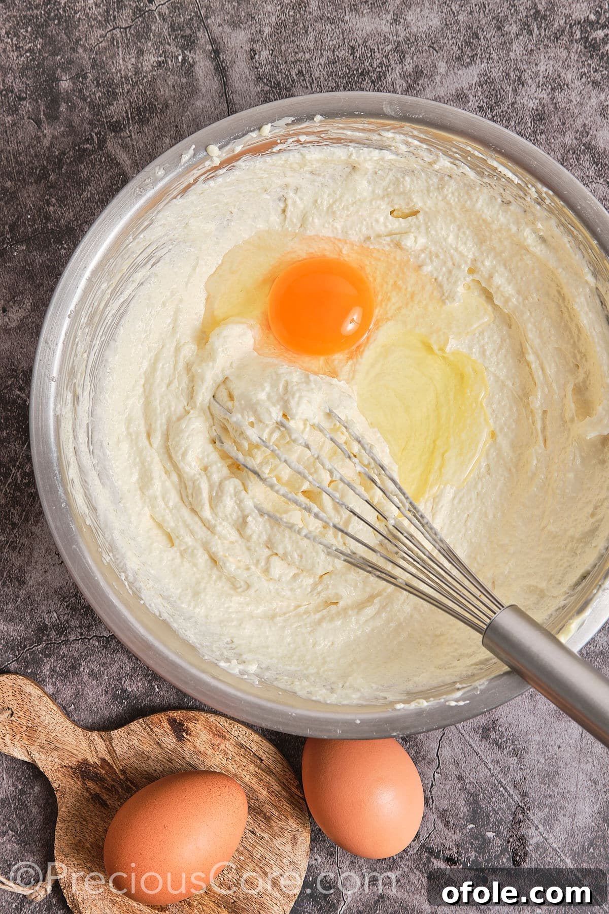 Southern Butter Pecan Pound Cake 7 An egg being added to the creamed butter and sugar mixture, ready to be mixed.