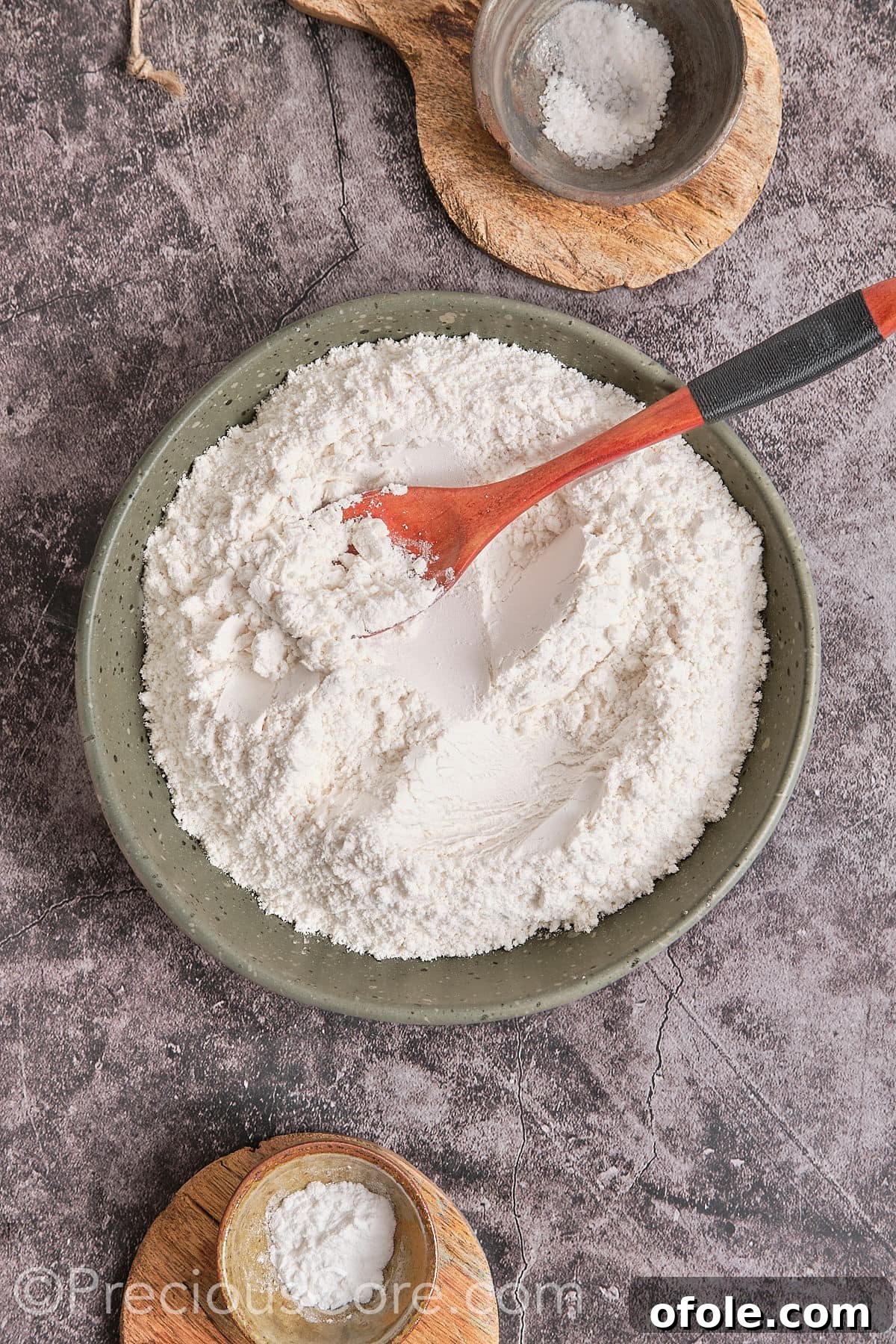 A bowl containing flour, baking powder, and salt, whisked together, ready to be added to the wet ingredients.