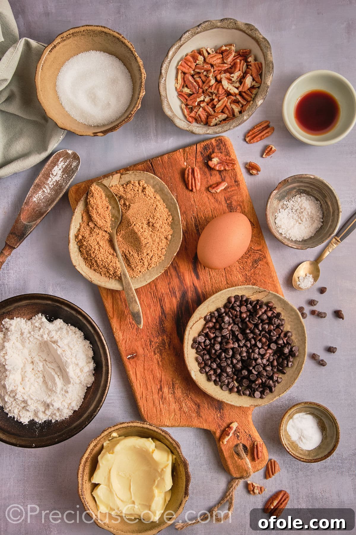 Decadent Brown Butter Pecan Delights 4 A beautifully arranged flat lay of all the essential ingredients for making brown butter pecan cookies, including flour, granulated sugar, brown sugar, butter, eggs, chocolate chips, and whole pecans.