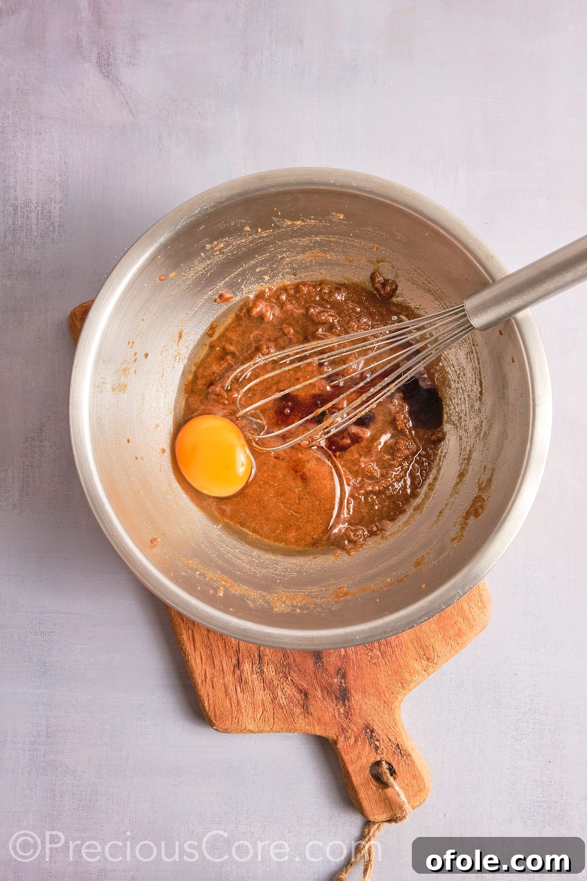 Decadent Brown Butter Pecan Delights 10 Adding a large egg and vanilla extract to the creamy brown butter and sugar mixture.