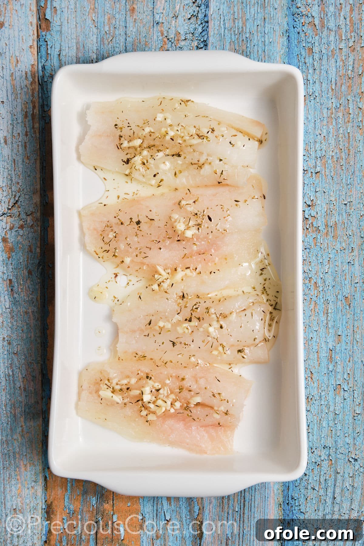 Vibrant Mediterranean Baked Fish 5 Cod fillets marinated in a pan.