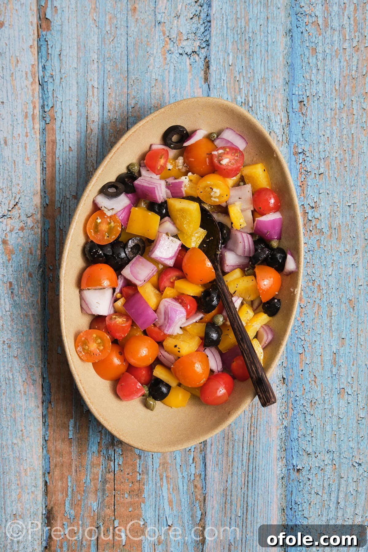 Vibrant Mediterranean Baked Fish 6 Diced veggies coated in olive oil and seasonings, in a bowl.