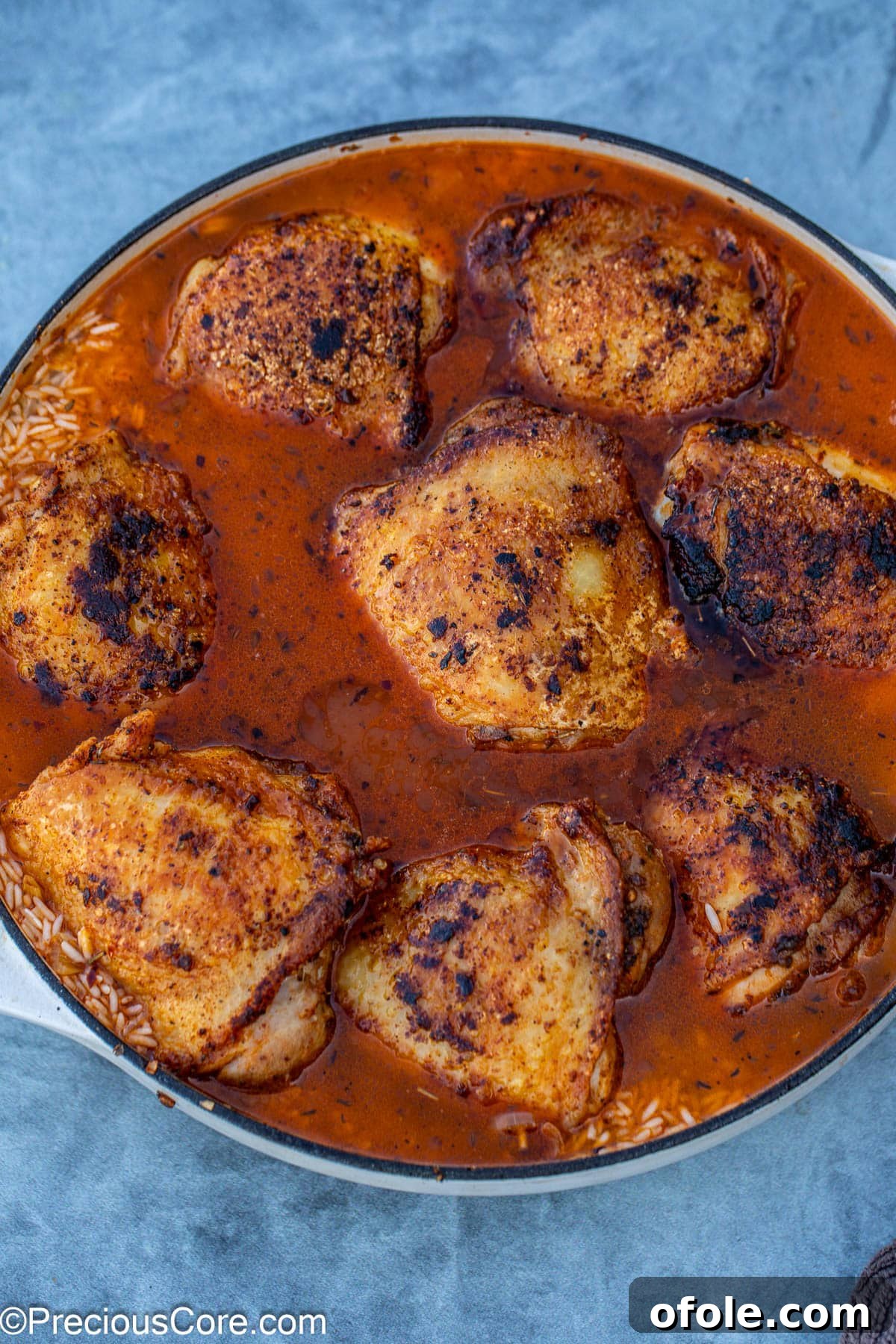 Savory One-Pot Chicken Thighs and Rice 11 Seared chicken thighs artfully placed back into the pot, resting on a bed of rice and broth.