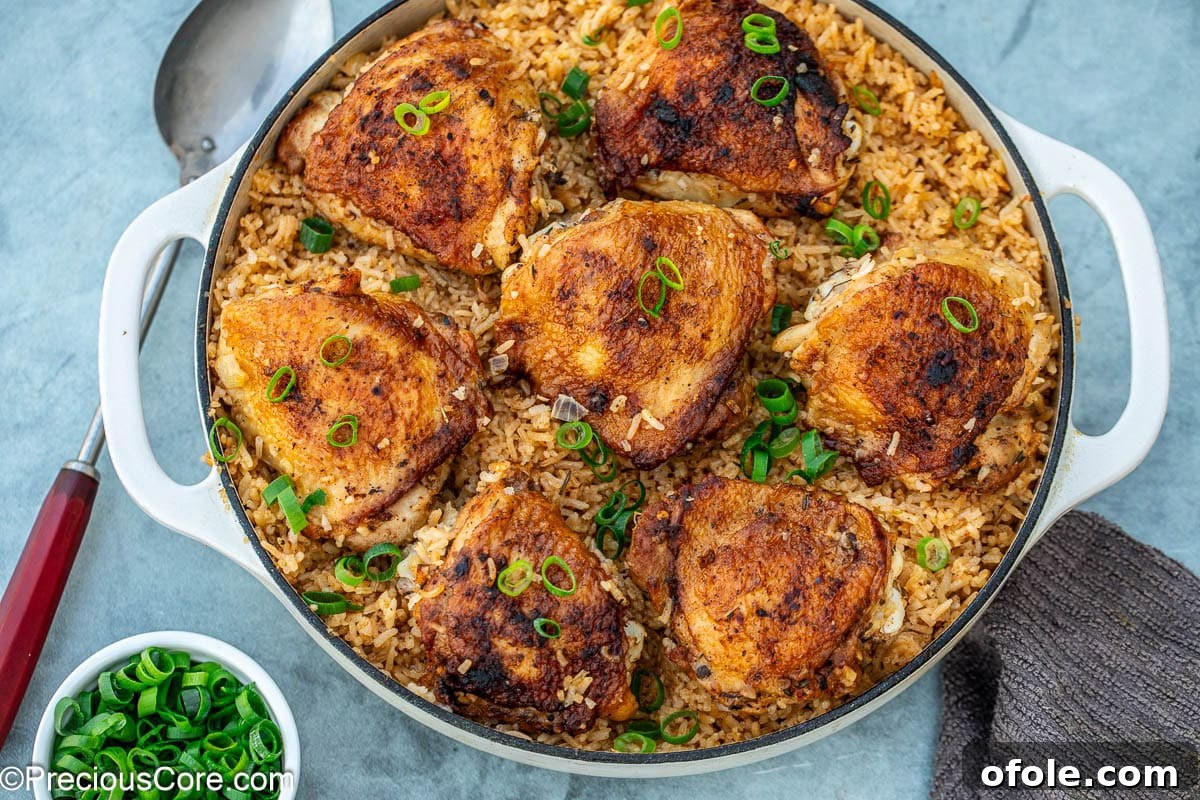 Savory One-Pot Chicken Thighs and Rice 3 Close-up of golden brown chicken thighs and fluffy rice cooked together in a large pot.