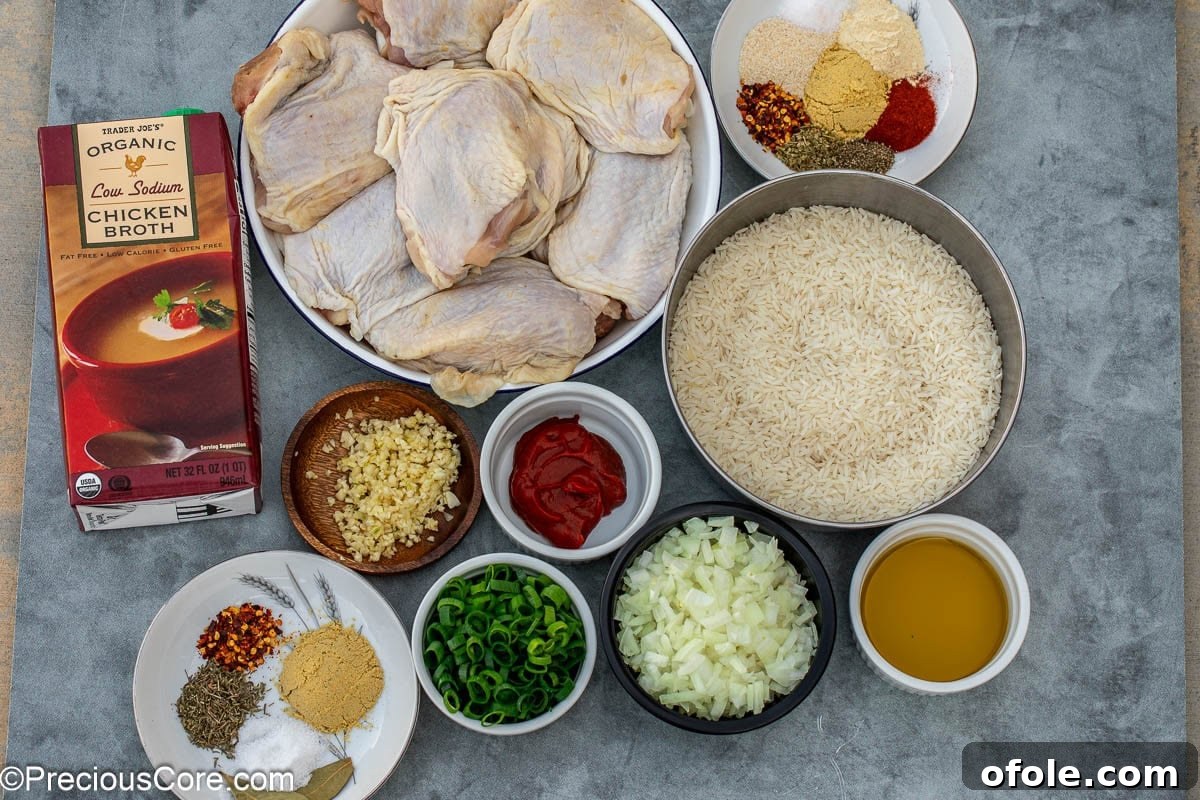 Savory One-Pot Chicken Thighs and Rice 4 A flat lay of fresh ingredients including chicken thighs, jasmine rice, onions, garlic, and various spices, laid out for the one pot chicken thighs and rice recipe.