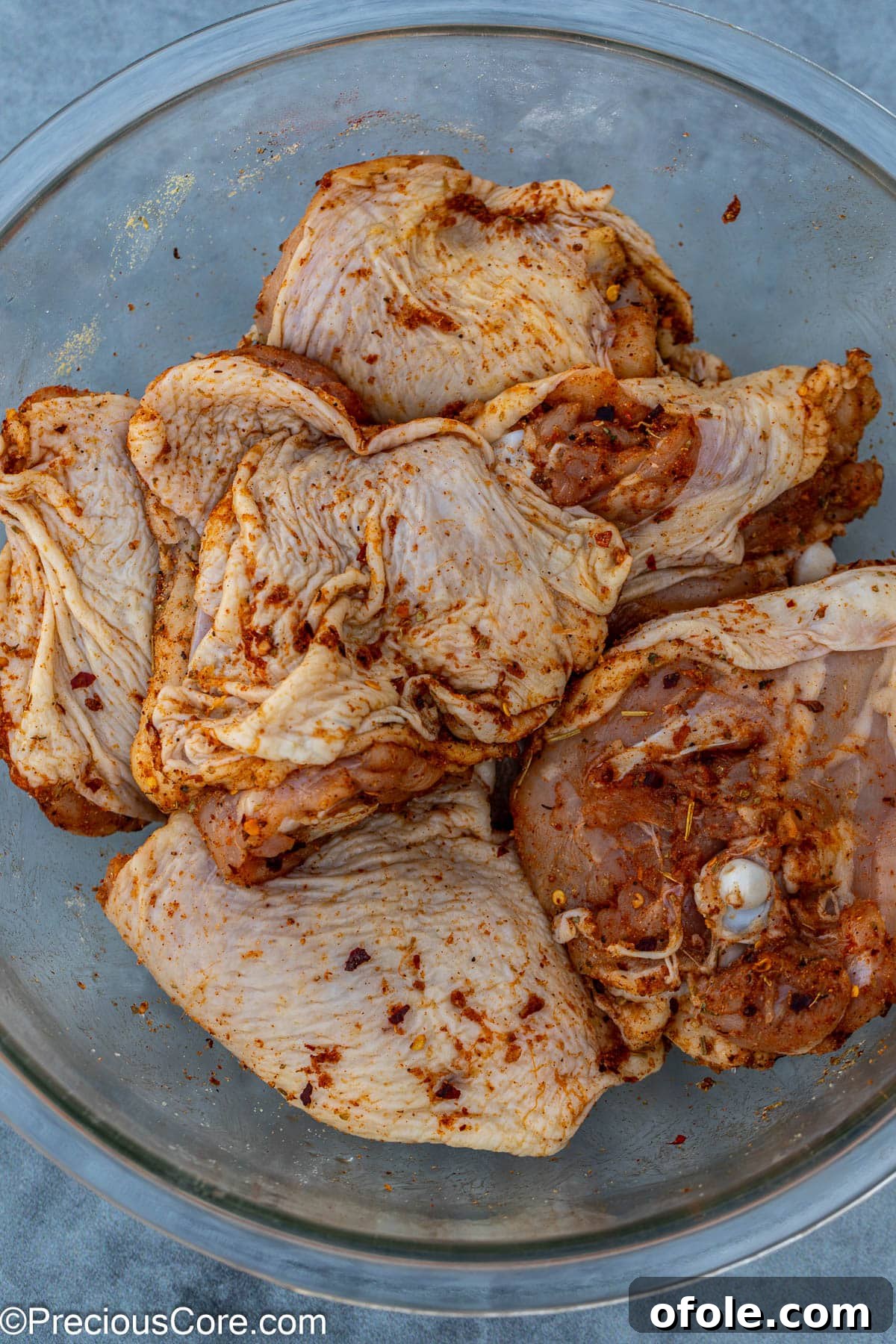 Savory One-Pot Chicken Thighs and Rice 5 Chicken thighs generously coated in a mix of fragrant spices, ready for searing.