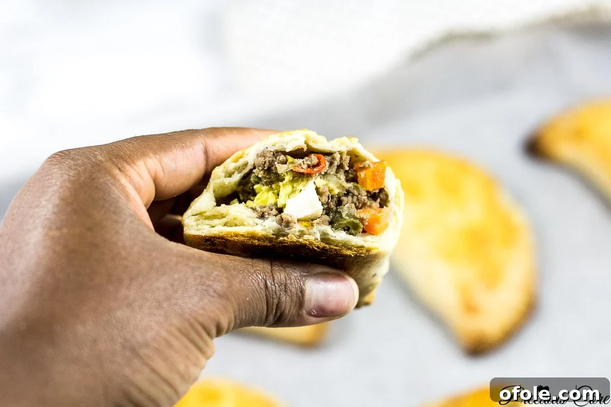 Spiced African Meat Pockets 5 A large platter filled with freshly baked African meat pies, ready to be served.
