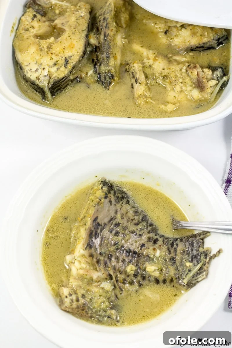 Mastering Cameroonian Fish Pepper Soup Step By Step 3 A vibrant bowl of Cameroonian Fish Pepper Soup, garnished and ready to be served, showcasing its rich, aromatic broth and fresh fish pieces.