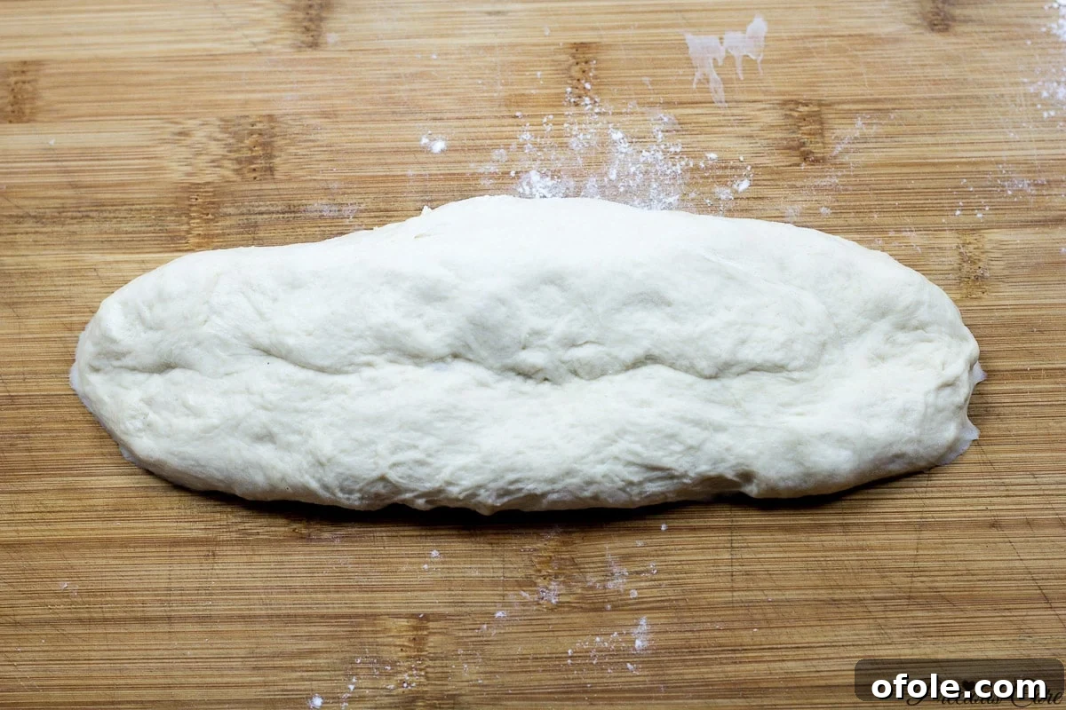 Effortless Crusty French Loaves 8 One piece of dough being shaped into a log for French bread