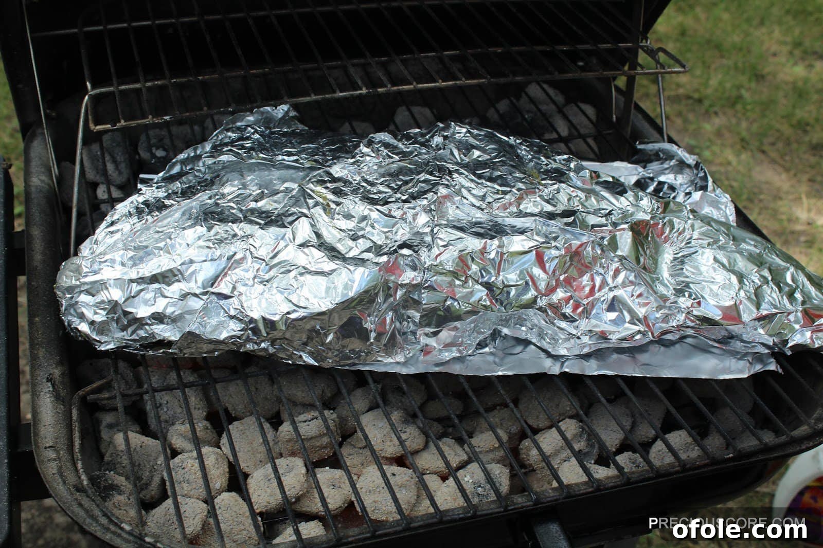 Foil-wrapped fish on grill