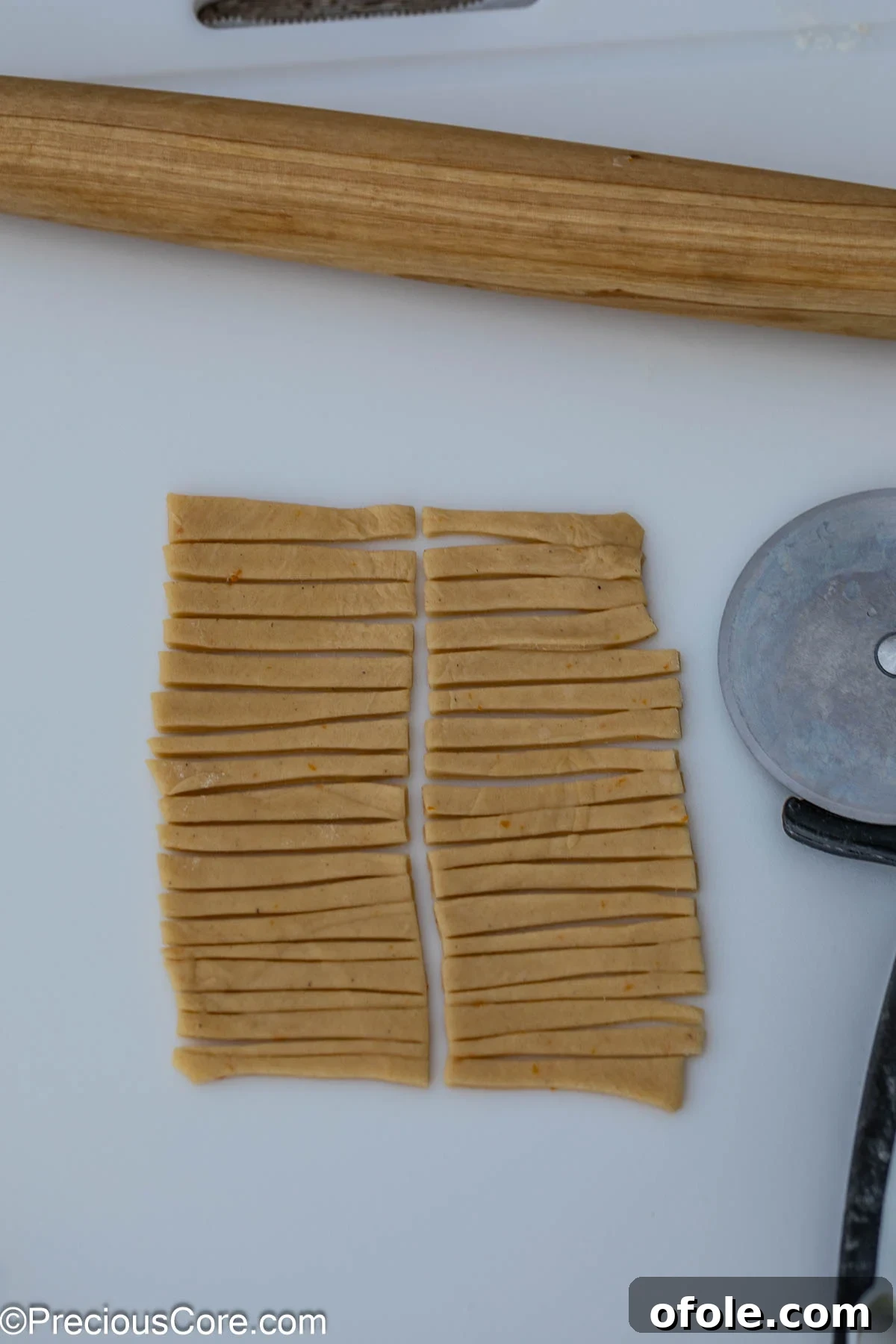 Chin Chin dough meticulously cut into uniform strips, ready for frying.