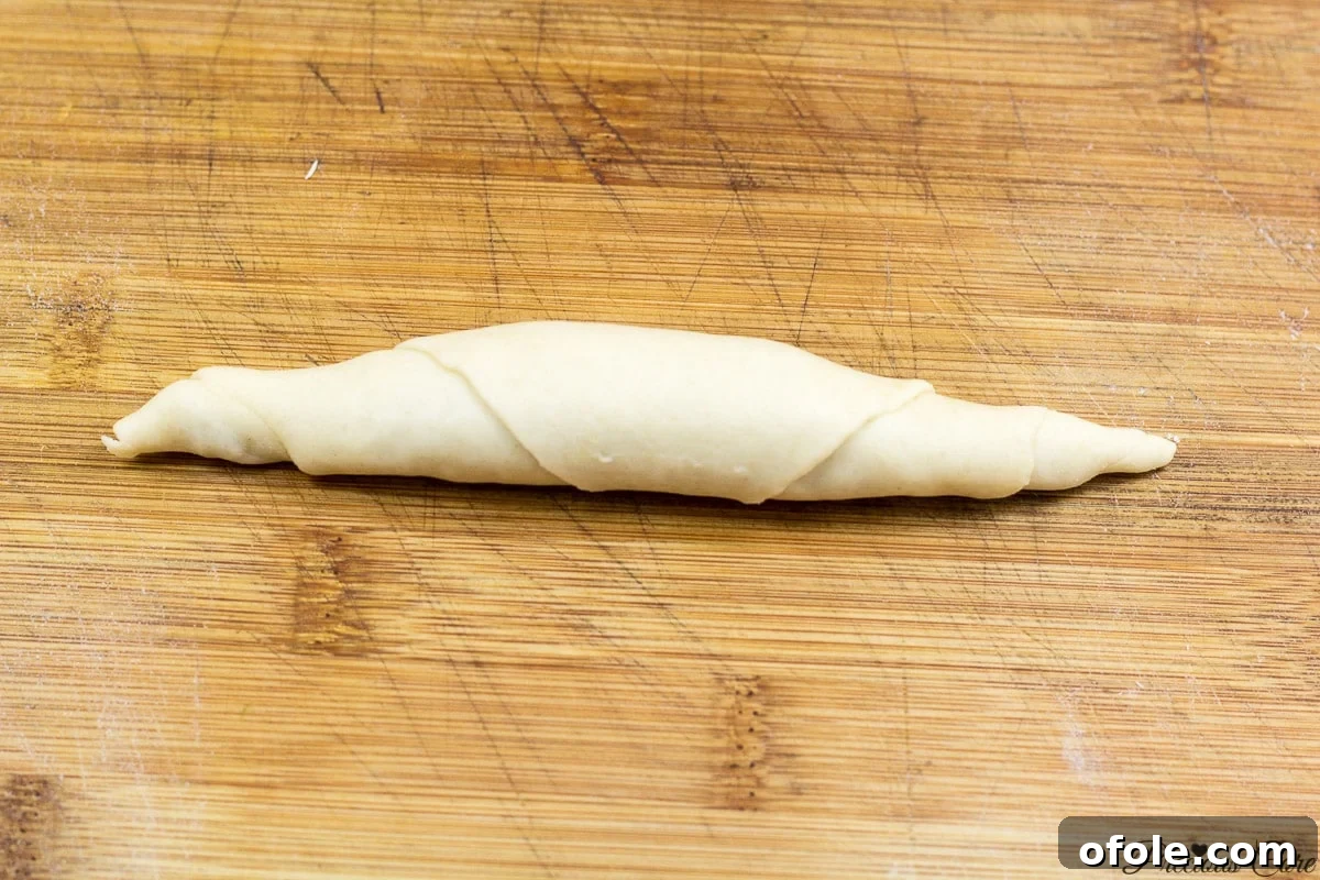 Rolling the filled dough to form a fish roll
