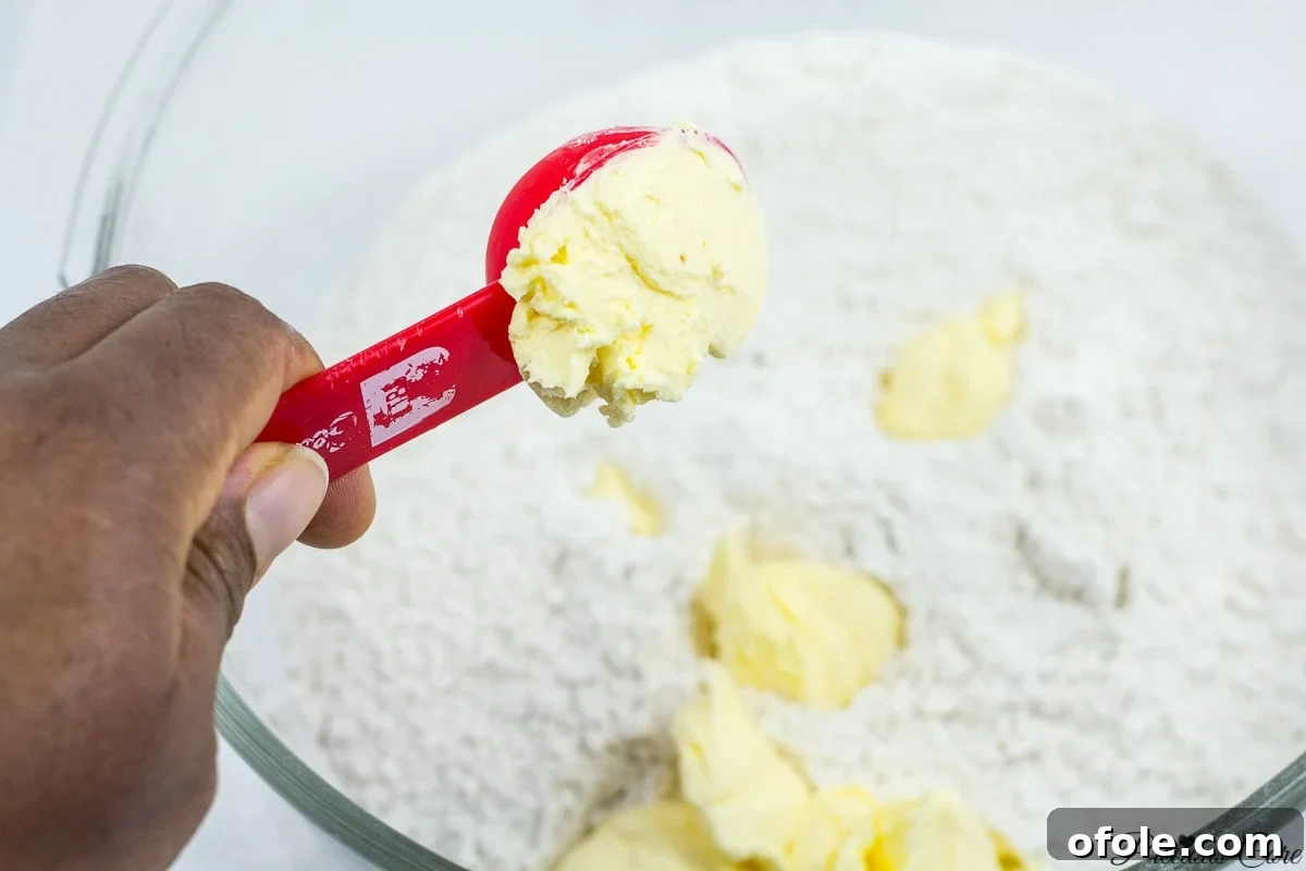 Adding margarine to flour for Cameroonian fish roll dough