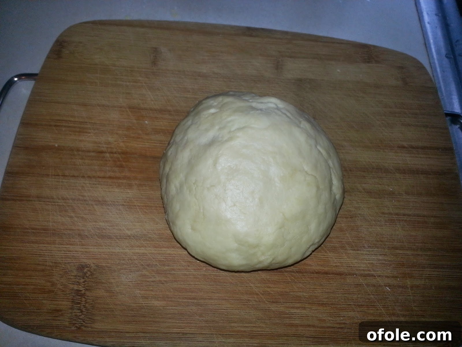 Perfectly Kneaded Milk Bread Dough Smooth, well-kneaded milk bread dough resting on a board.