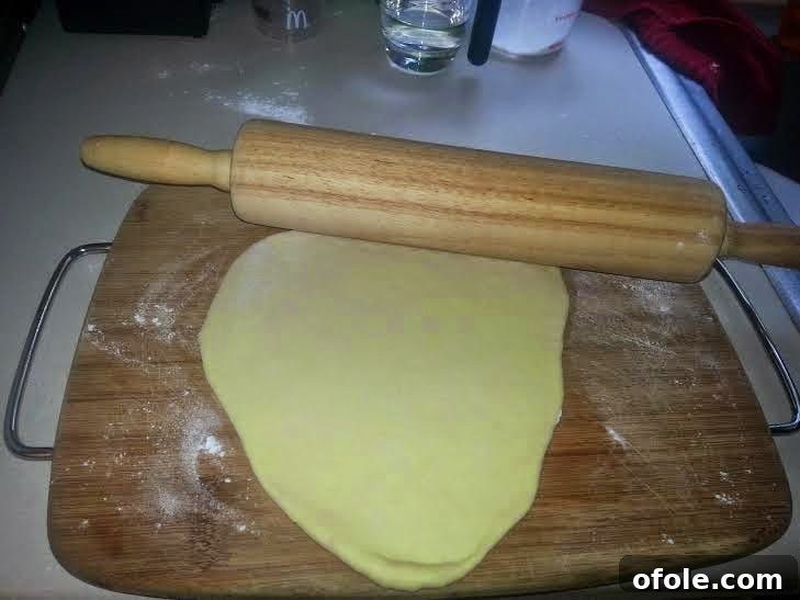 Rolled Out Milk Bread Dough A single piece of dough rolled out into an oval shape.