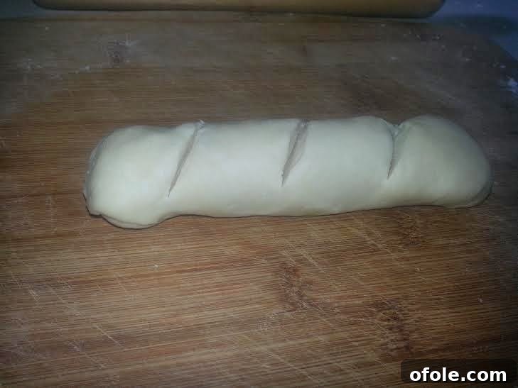 Scored Milk Bread Dough Log Dough log with three diagonal cuts on top before the second rise.
