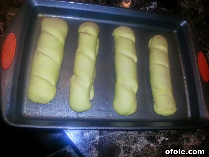 Perfectly Proofed Milk Bread Dough Proofed milk bread loaves, visibly risen on the baking tray.
