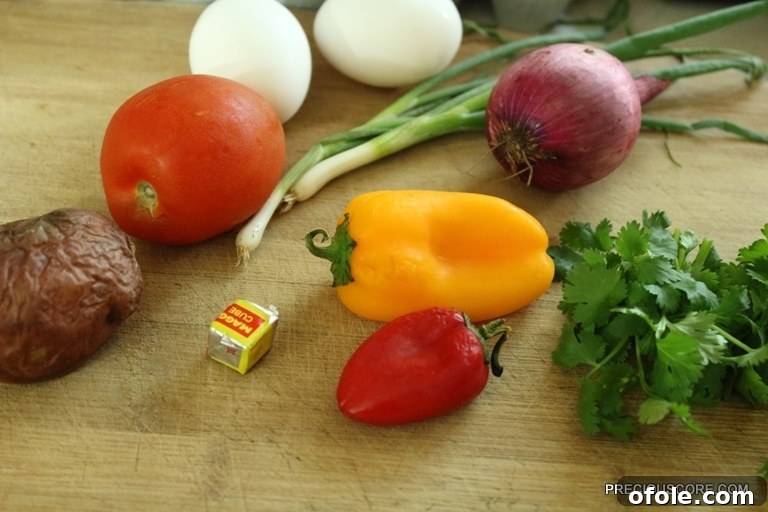 Hearty Breakfast Frittata 4 Ingredients for frittata: baked potato, colorful bell peppers, onion, eggs, tomato, seasoning cube, and cilantro