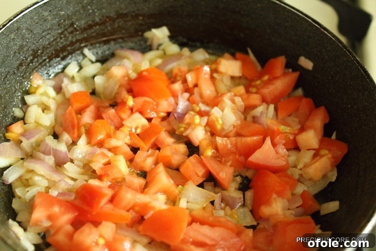 Hearty Breakfast Frittata 8 Mixed vegetables including potatoes, bell peppers, tomatoes, and onions sautéing in a skillet