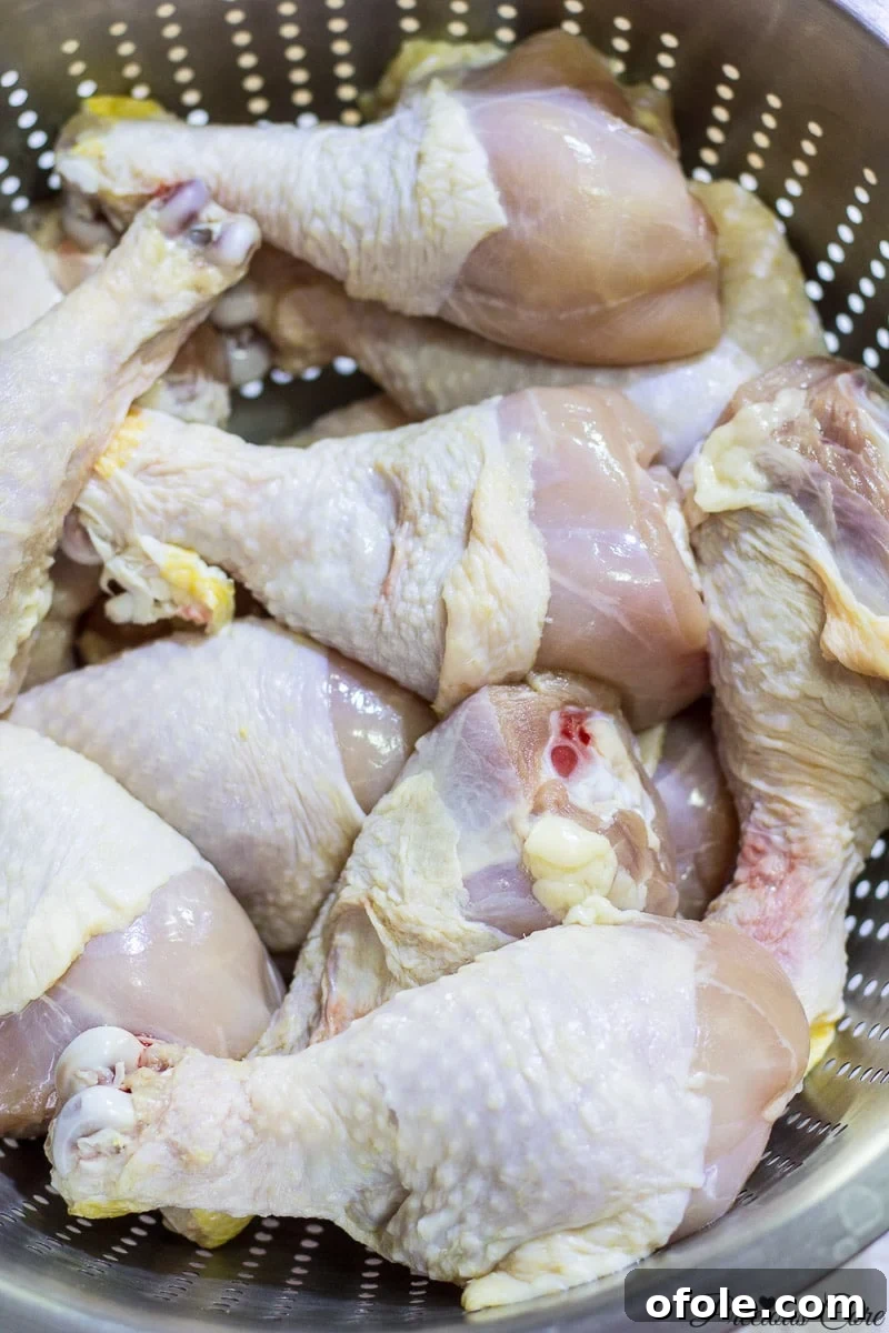 Chicken drumsticks in a porous pan, ready for seasoning.