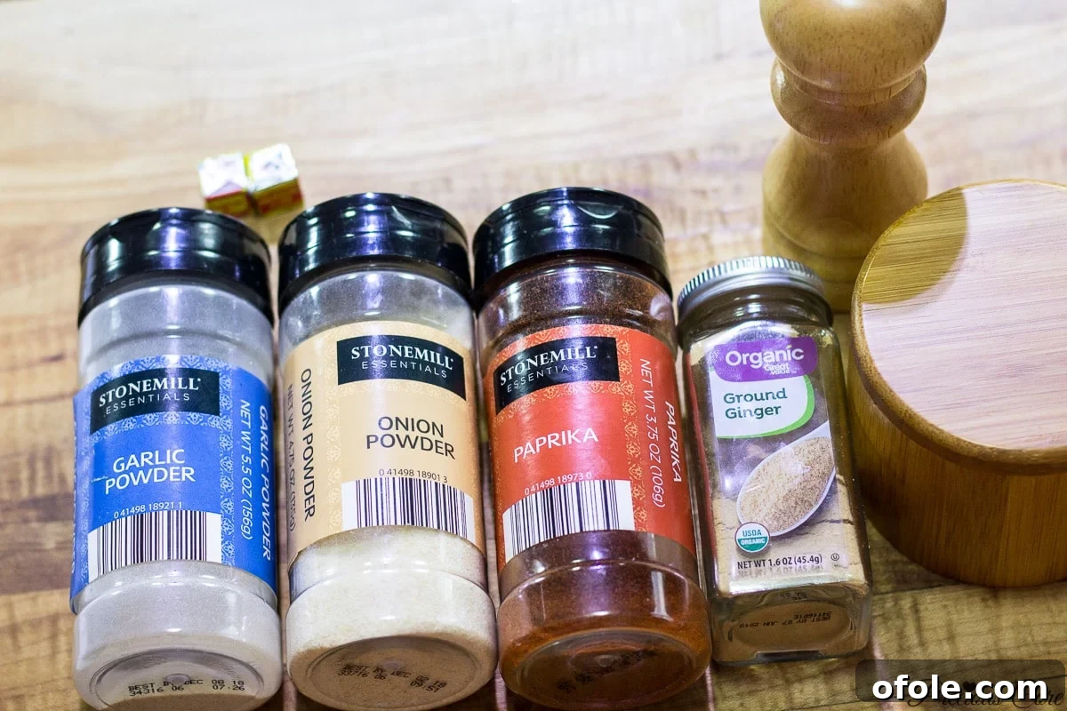 A selection of dry seasoning and spices for grilled chicken, including paprika, garlic powder, and ginger powder.