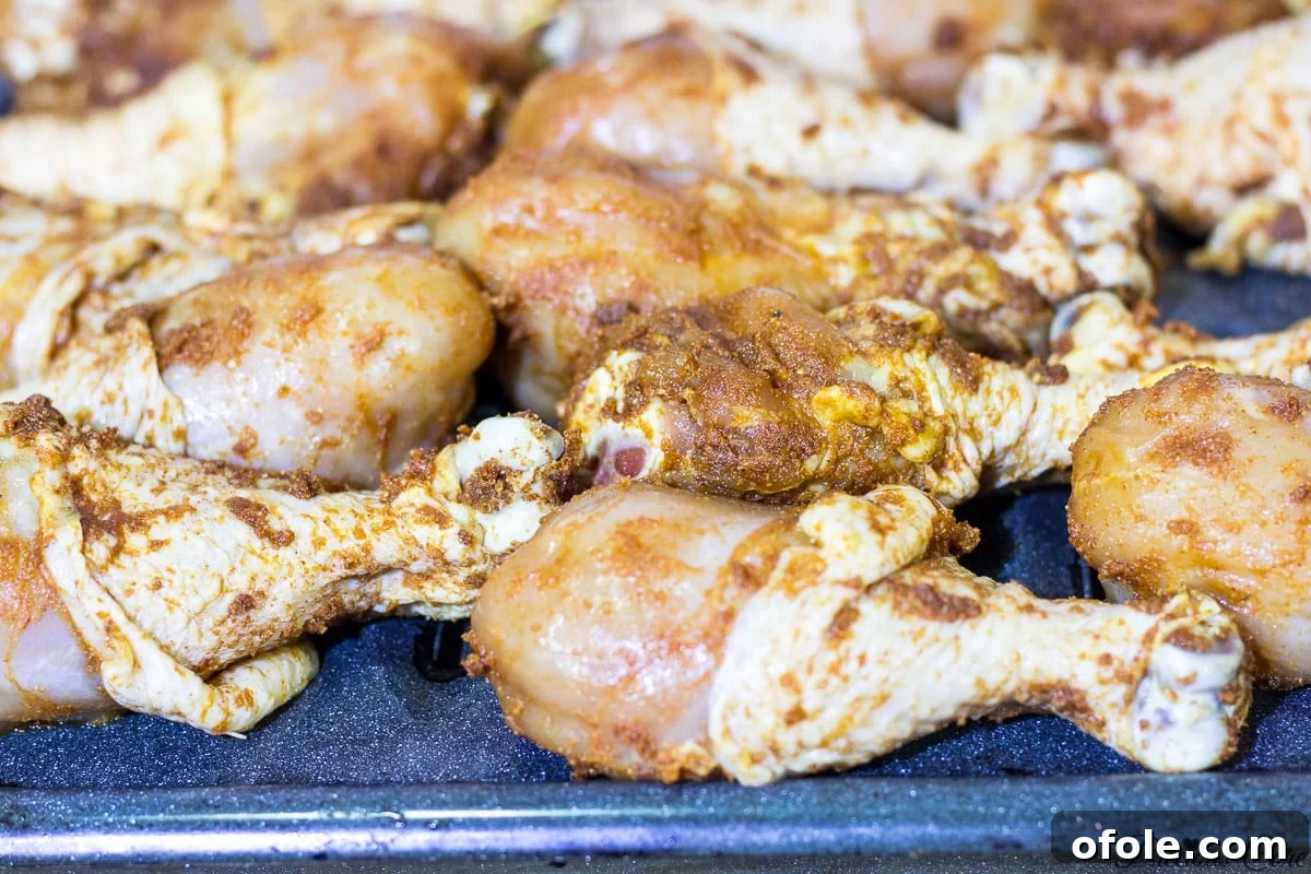 Raw chicken drumsticks generously coated with African-inspired dry marinade.