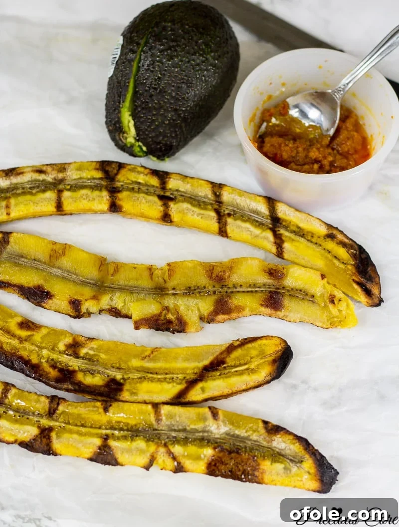 Halved plantains with grill marks, showing a golden-brown exterior and soft interior.