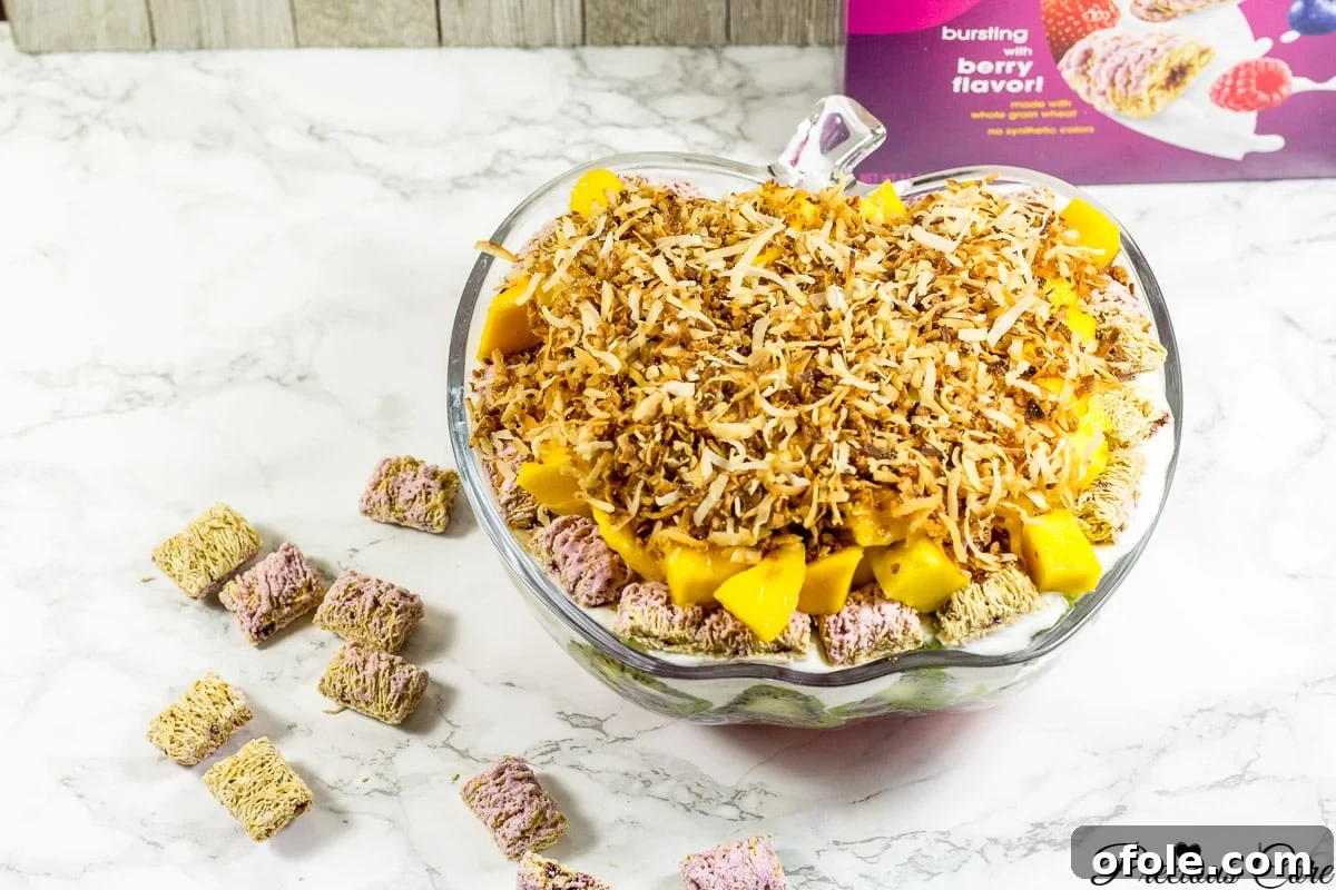 The finished 7-layer fruit salad, beautifully layered with fresh fruit and a topping of mango and toasted coconut, perfect for summer.